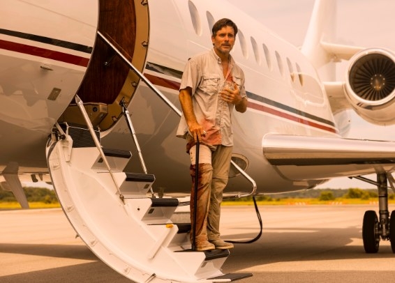 Ward stands on the stairway of a private jet, bleeding from several wounds