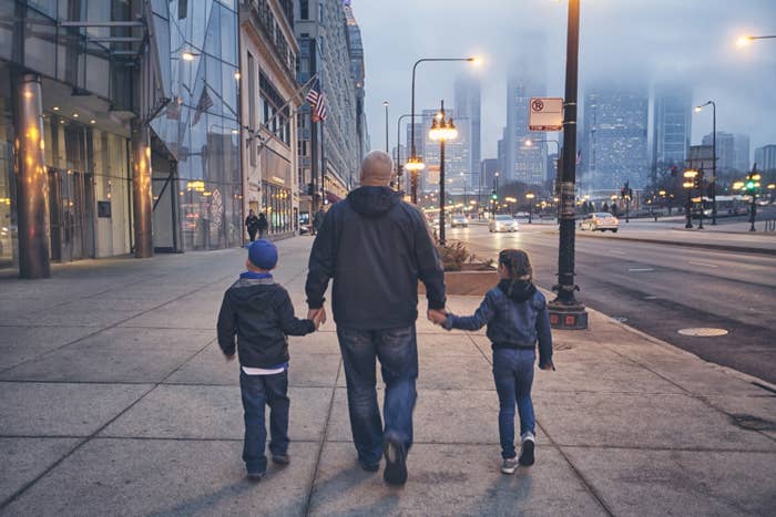 a father holding his children's hands