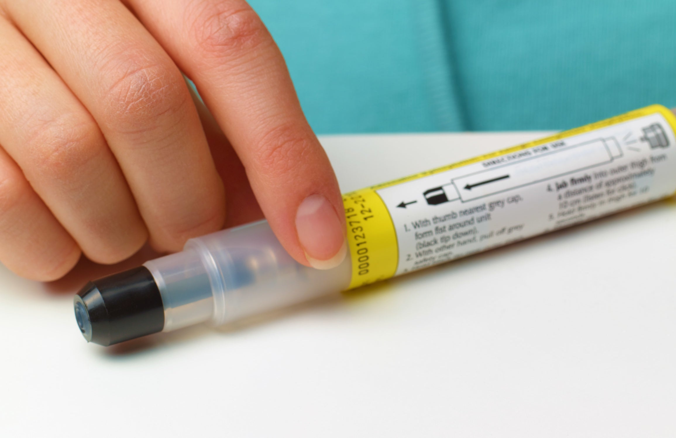 a person holds an epipen