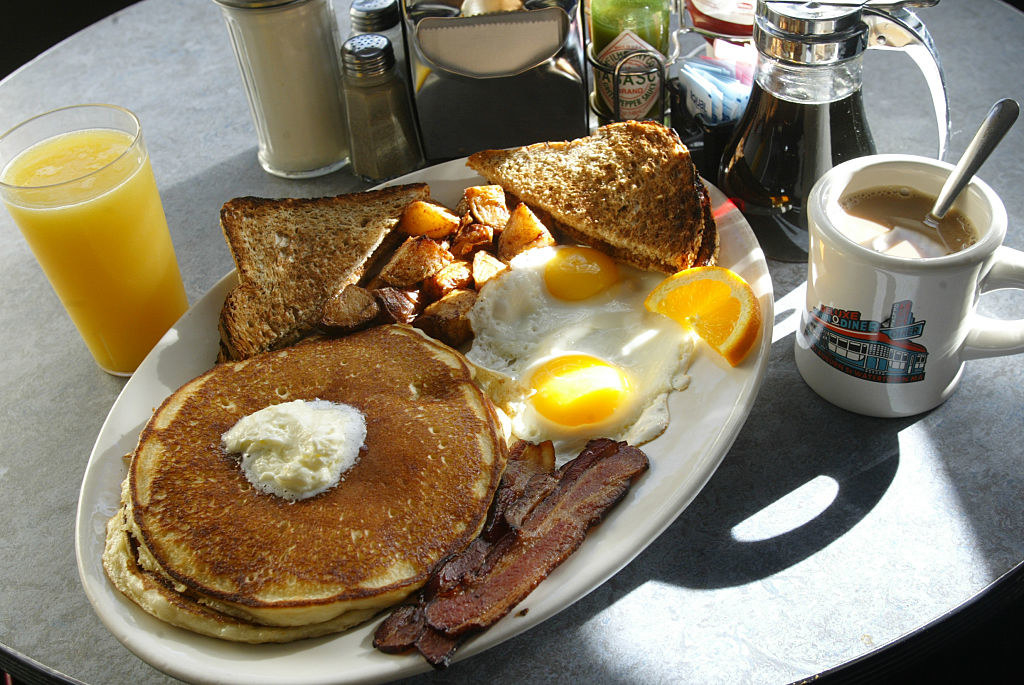 A big plate of pancakes, eggs, and bacon.