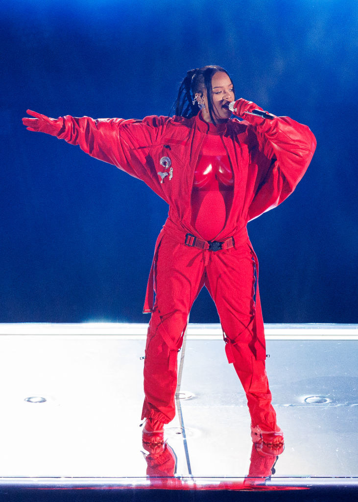Rihanna onstage in a red jumpsuit