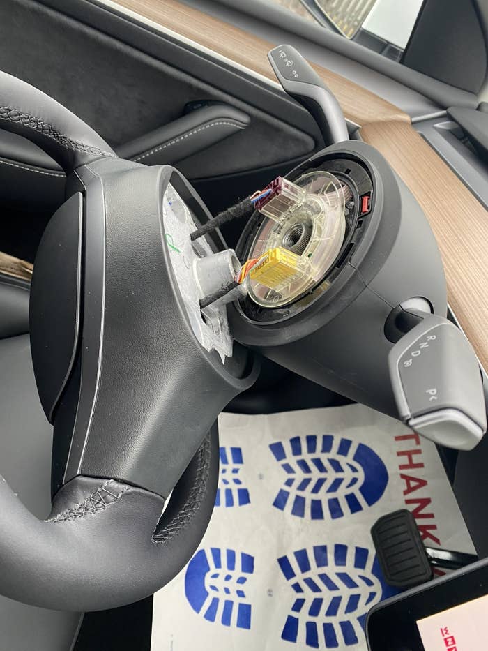 Patel's steering wheel is detached from the steering column showing the car's inner workings
