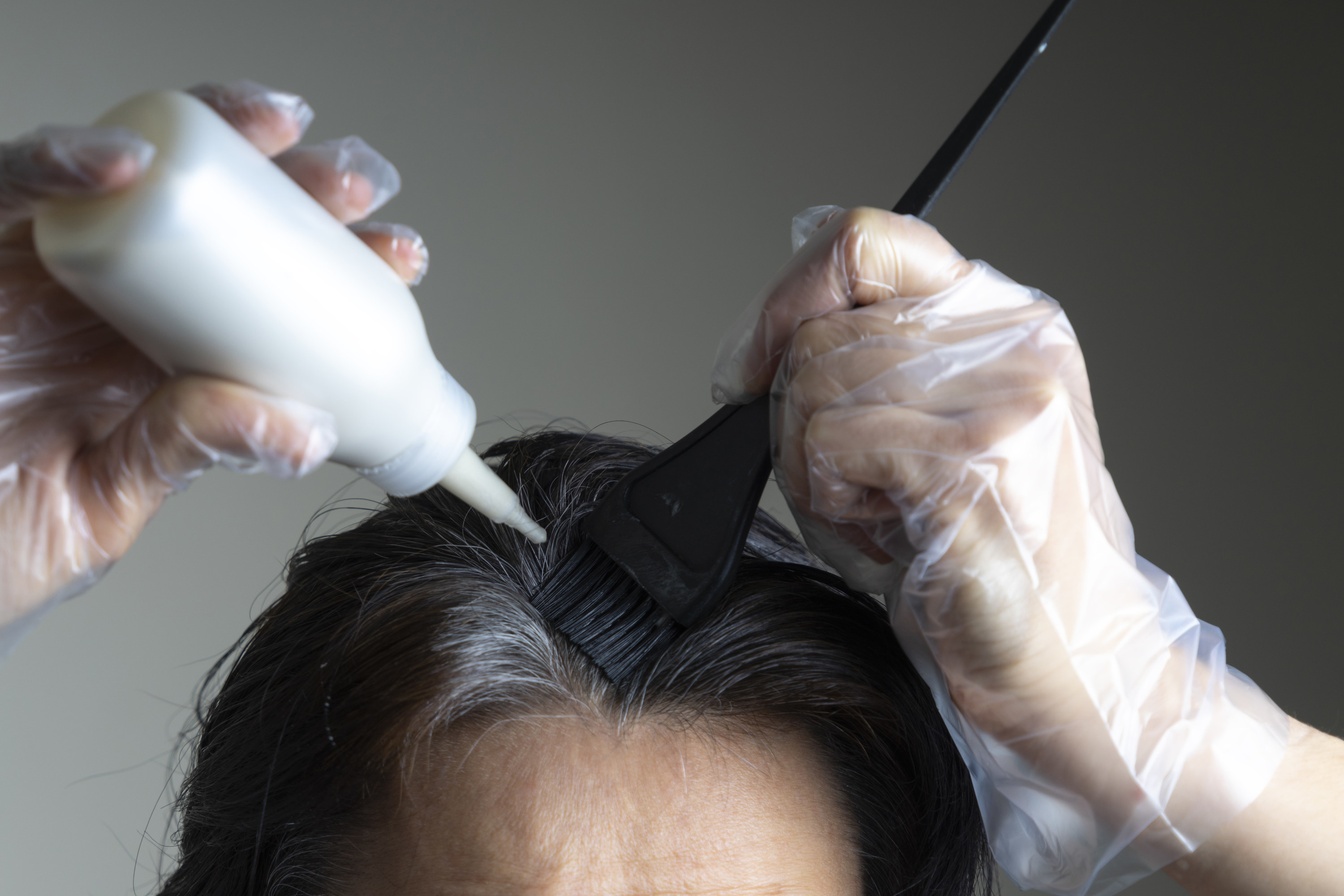 A person dyeing their hair at home