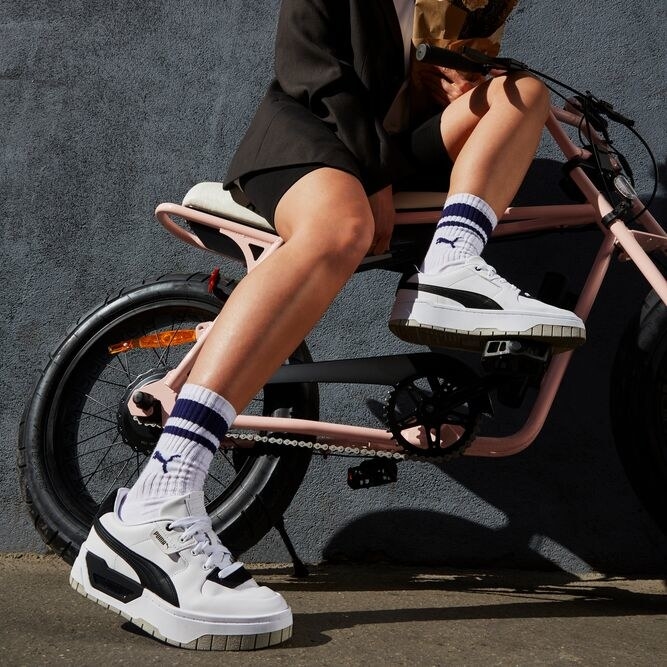 Person wears Puma&#x27;s Cali Dream sneakers while on a bike