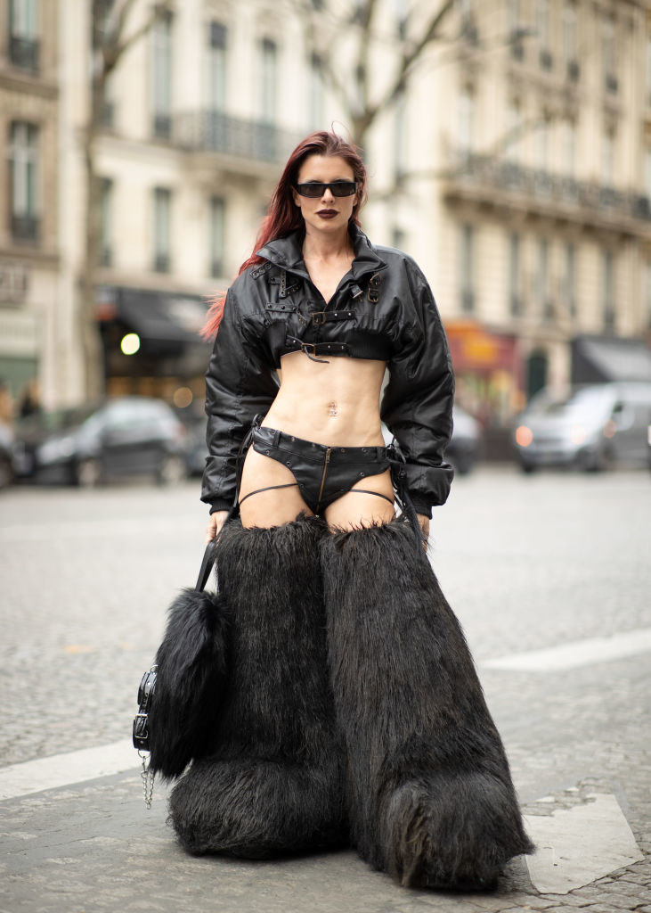 Julia in a leather long-sleeved top and bikini shorts with huge, thigh-high furry boots