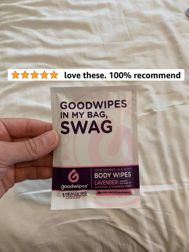 A reviewer holding a pack of the wipes