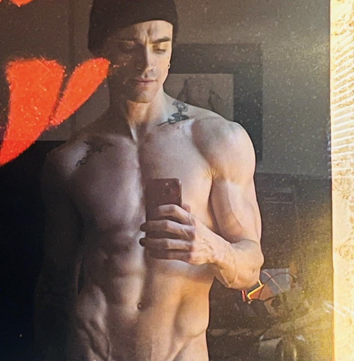 A shirtless mirror selfie of Jordan showing off his abs