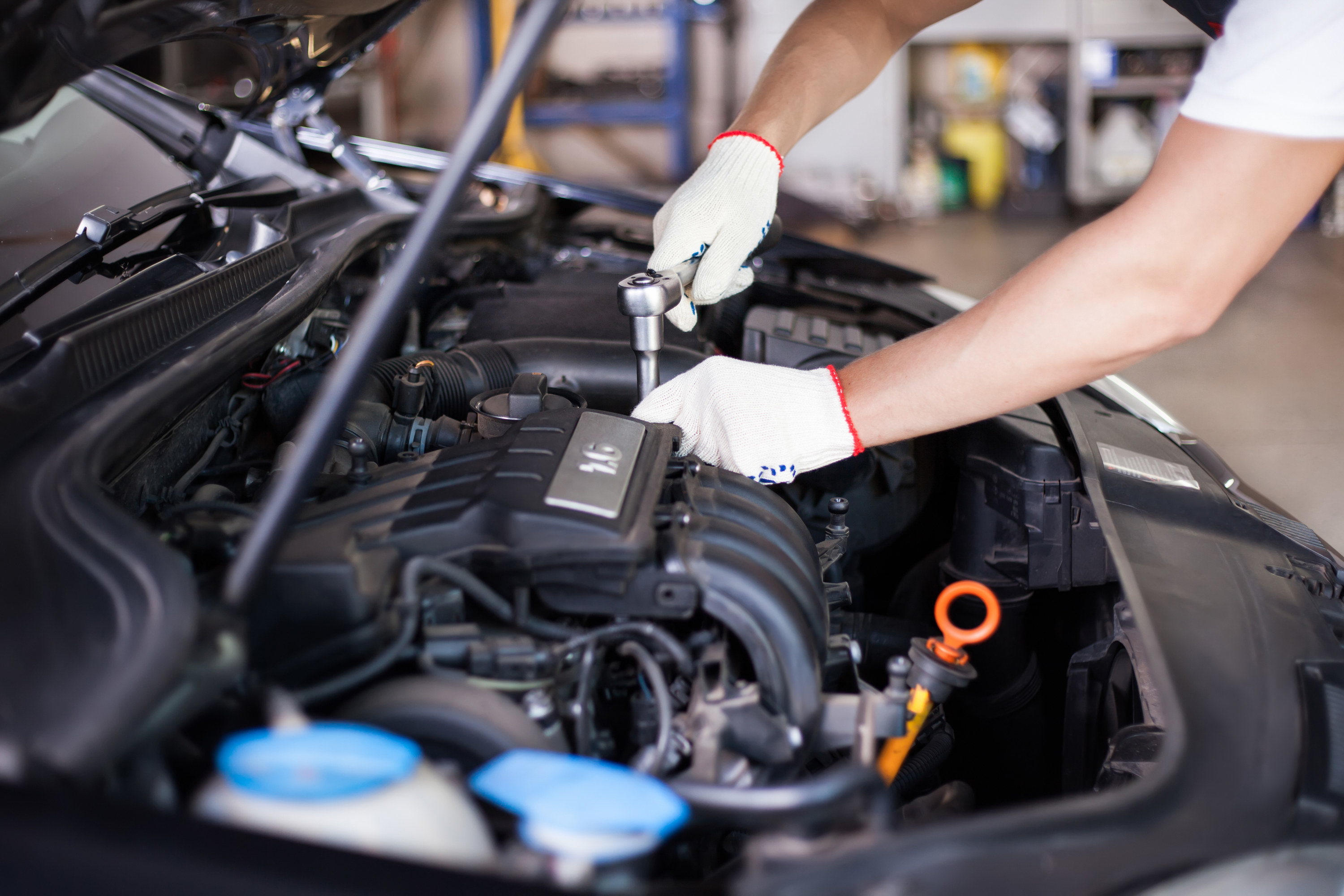 Hands of car mechanic in auto repair service