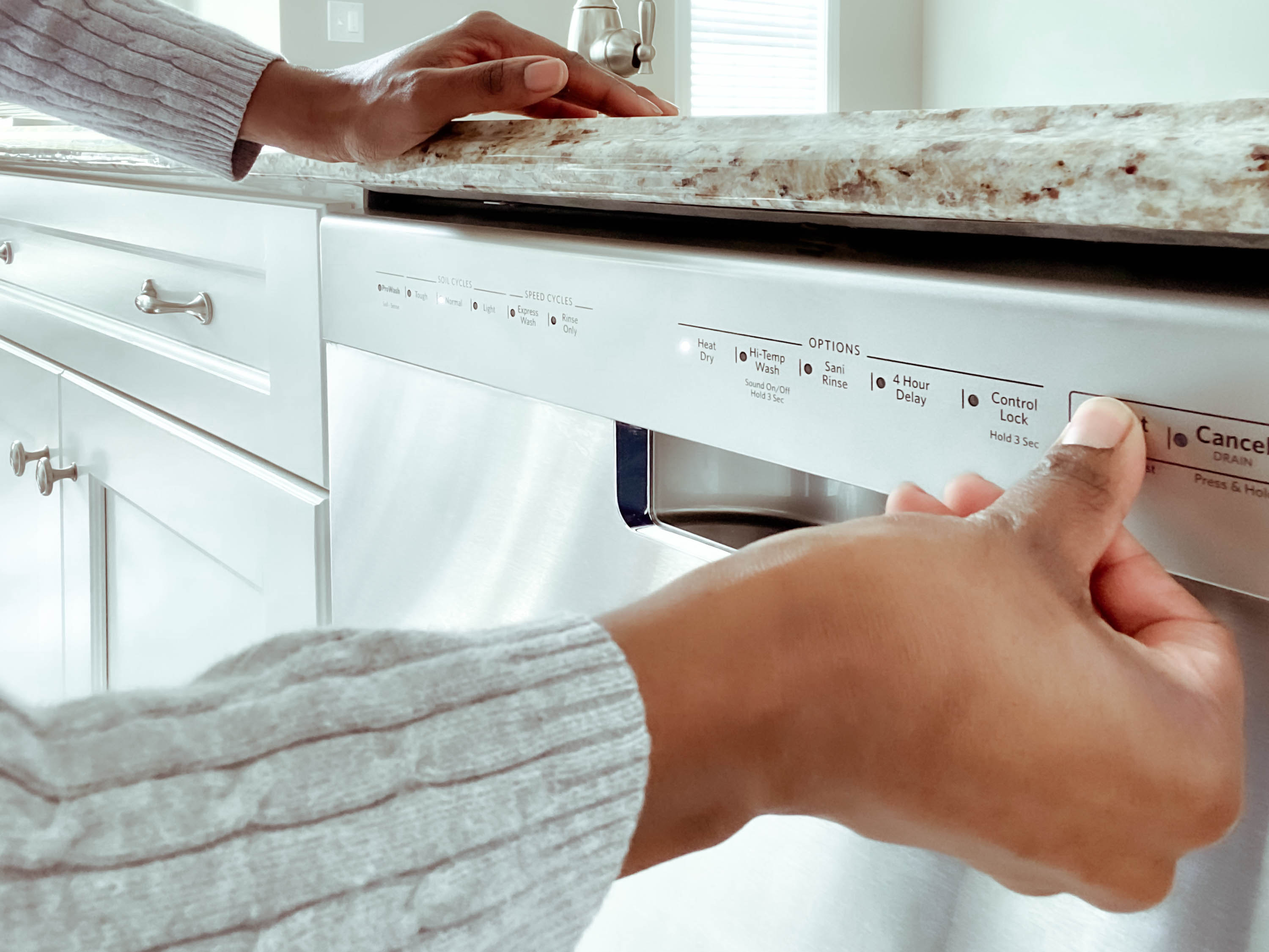 woman hitting dishwasher setting