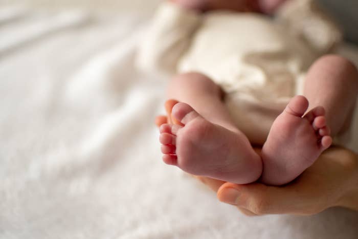 Close-up view of a baby feet holded by her mom