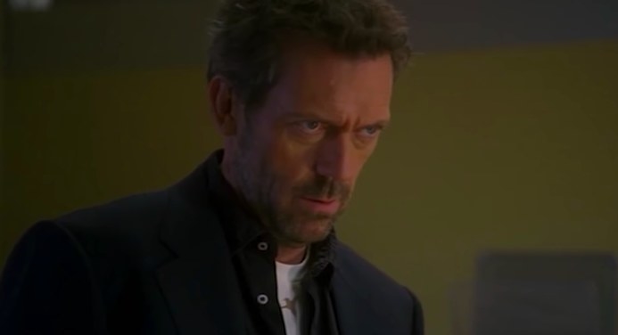 House frowns while looking at a patient