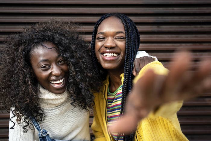 Stock photo of black young friends smiling and looking at camera