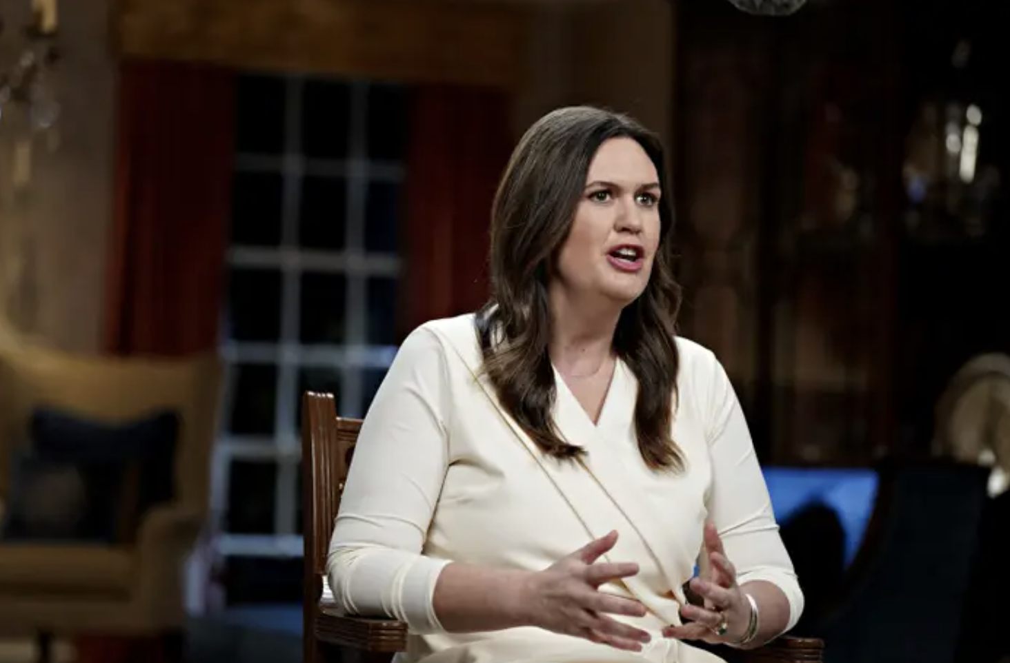 Sarah Huckabee Sanders sits in a chair gesturing with her hands