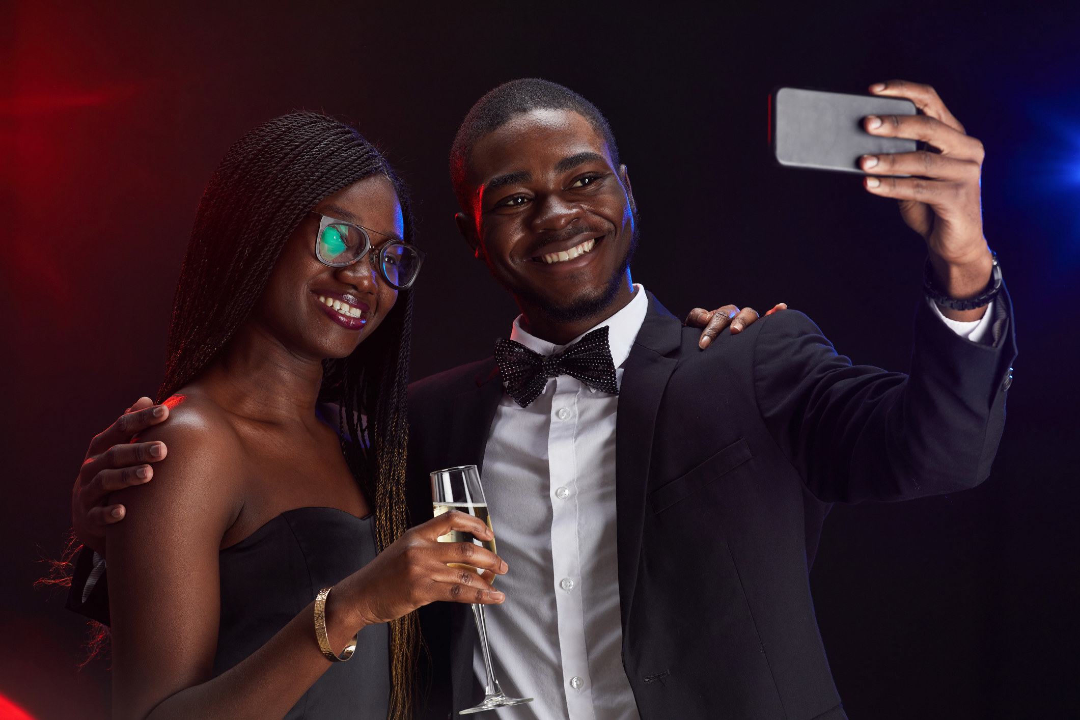 Young high school boy taking a selfie with a high school girl at a party