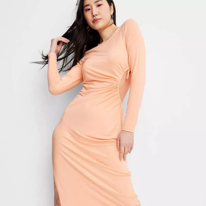 model wearing long-sleeve orange cutout dress