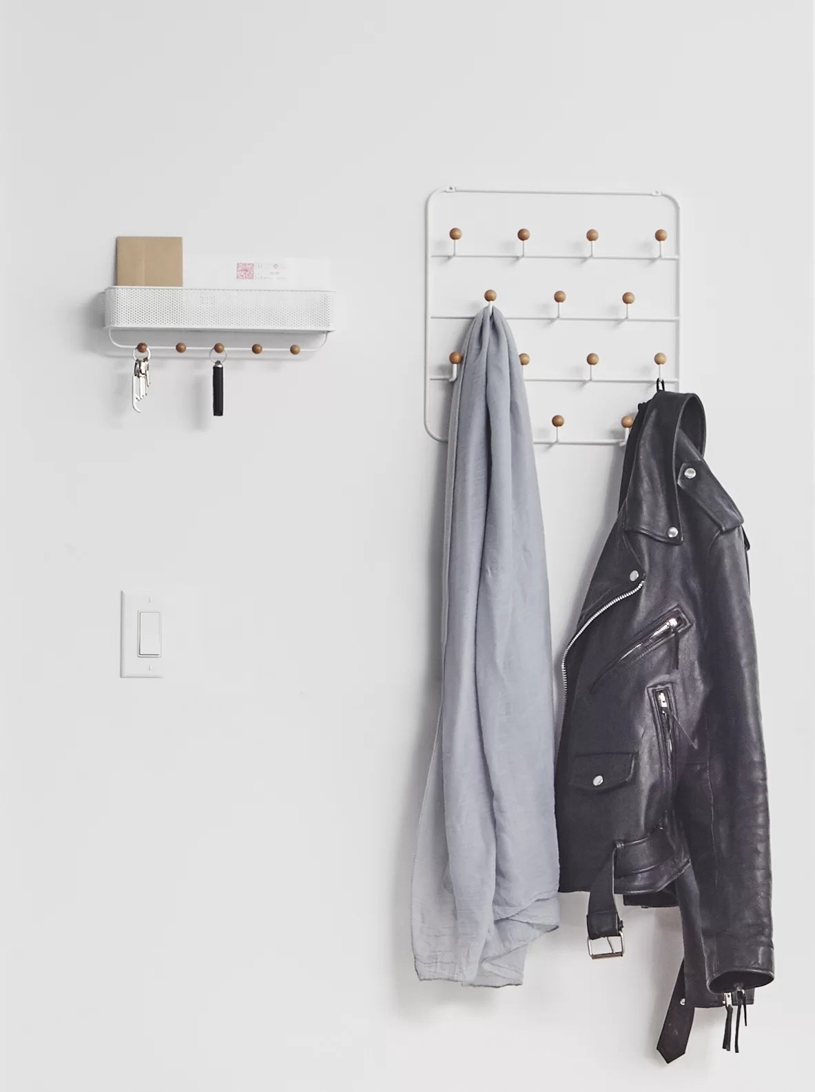 an over-the-door organizer holding a shirt and leather jacket