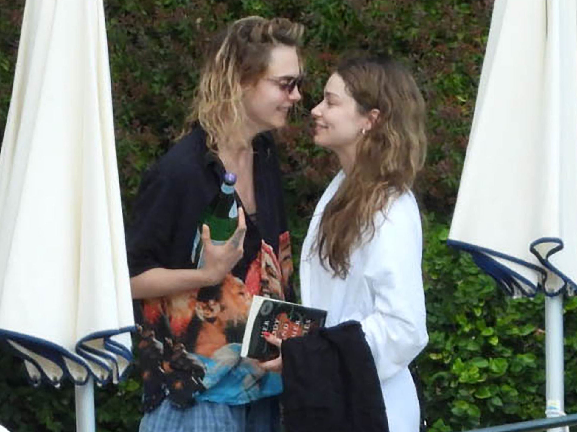 Cara and Minke smile at each other while standing outside