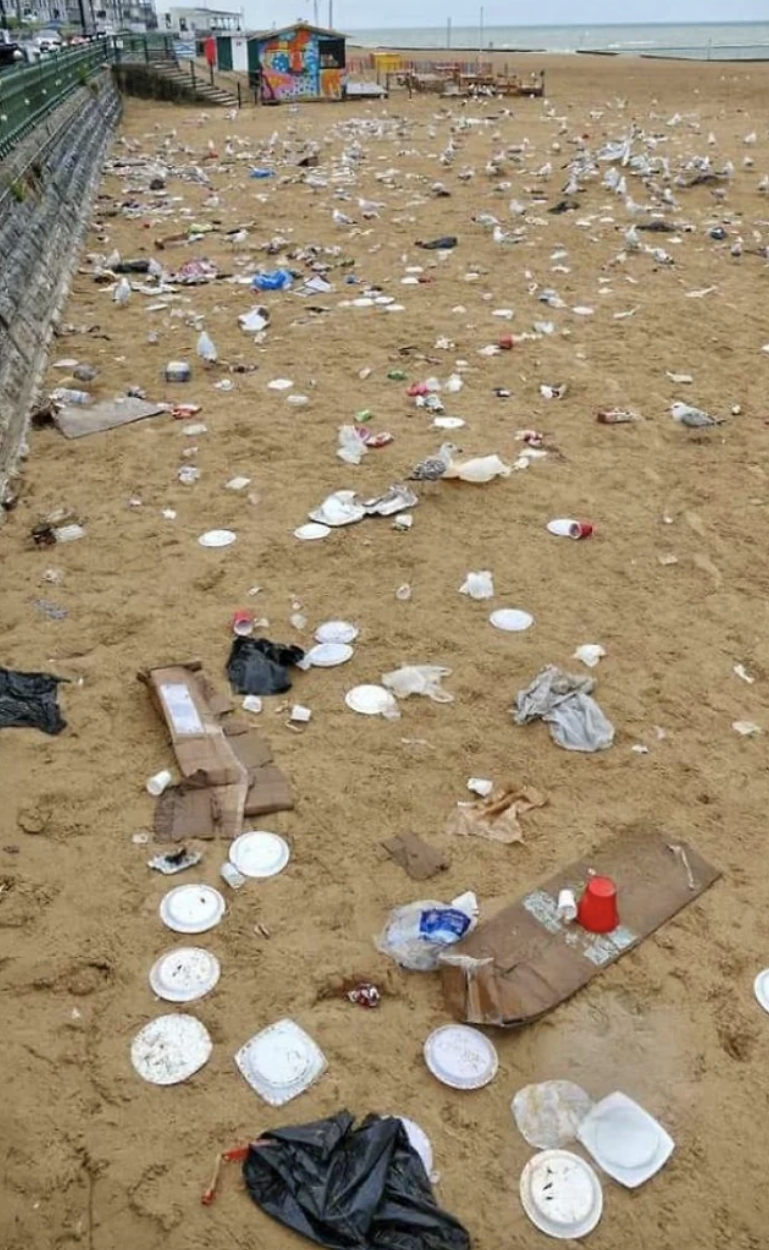 A beach is completely covered in trash