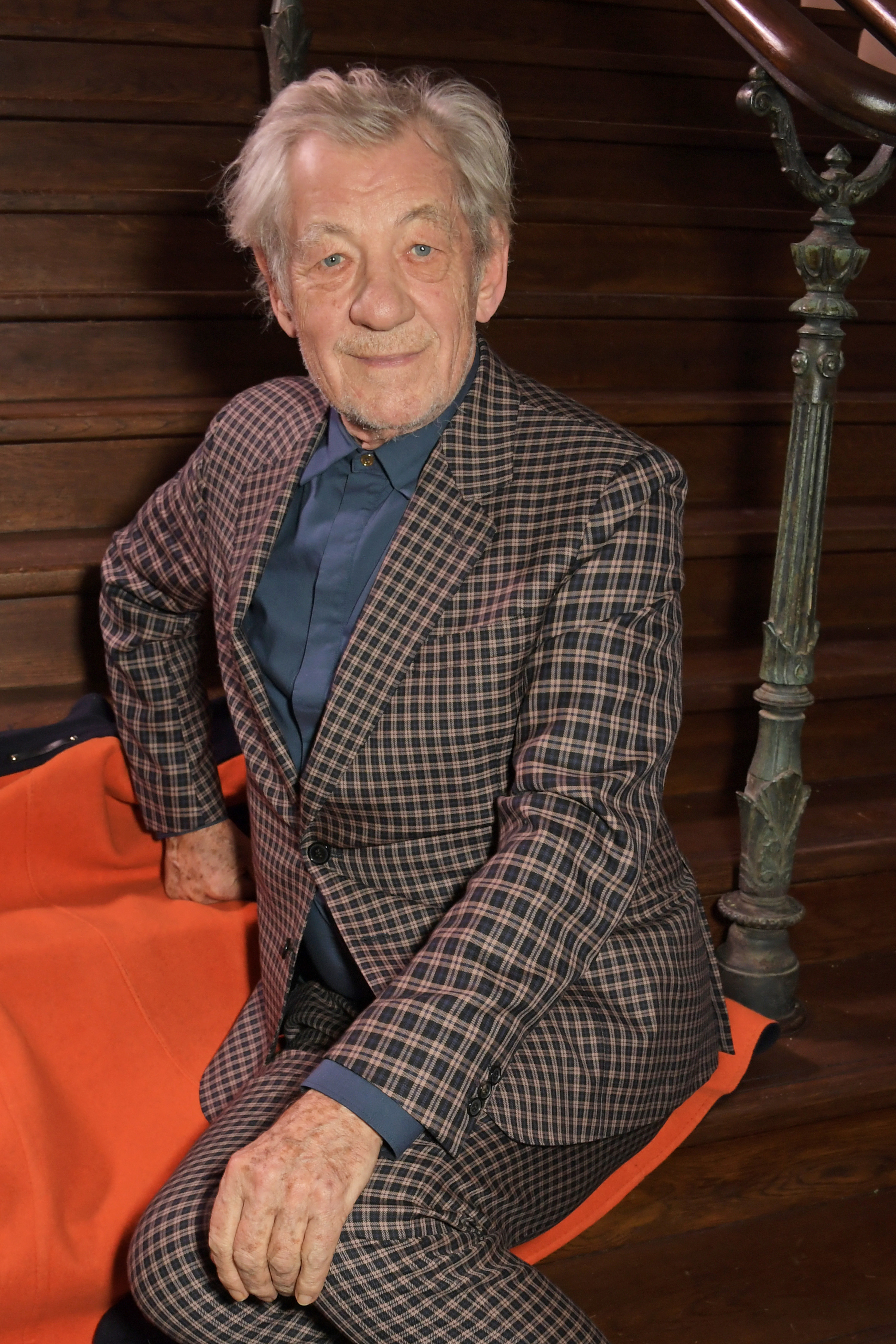 Sir Ian McKellen sitting and posing for a photo