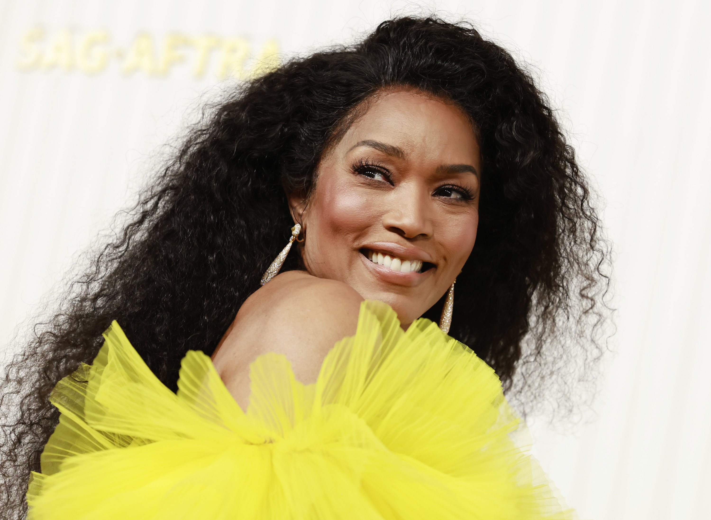Angela Bassett smiling and posing on a red carpet