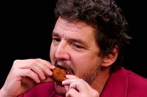 Pedro Pascal eating a chicken wing on Hot Ones