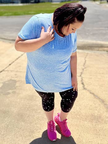 Reviewer wearing light blue top with short sleeves, black leggings and pink sneakers