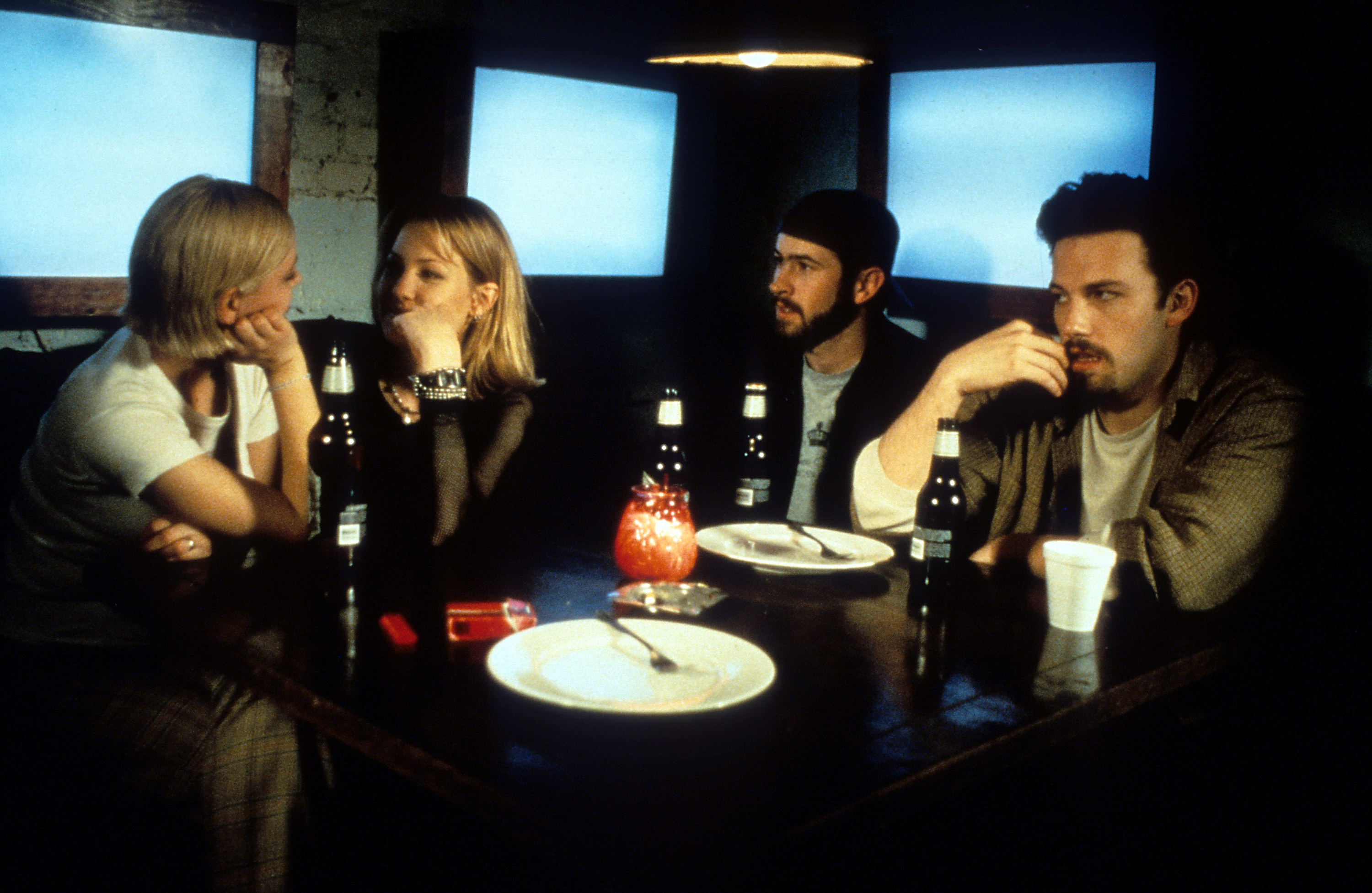 Ben Affleck, Jason Lee and Joey Lauren Adams sitting at a dining table in a scene from the film &#x27;Chasing Amy&#x27;, 1997