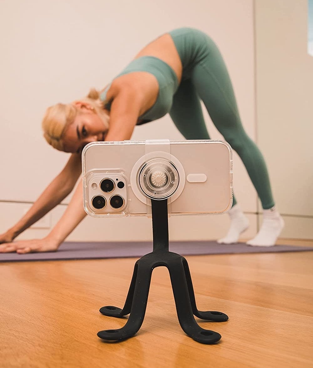 A person doing yoga while the mount holds their phone up