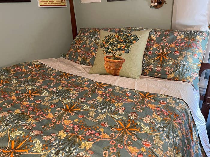 A reviewer&#x27;s photo showing the floral bedding on their bed