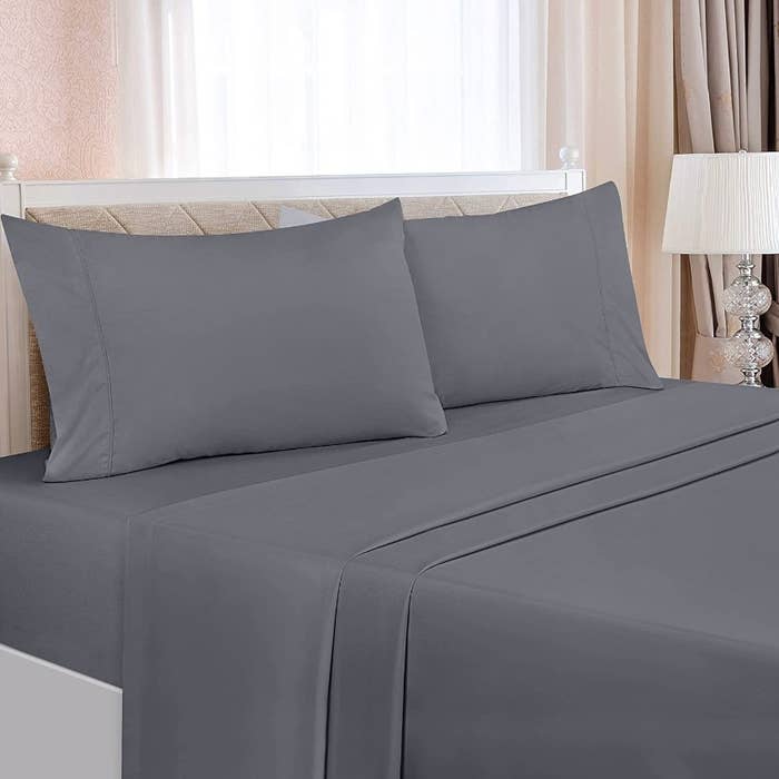The four piece bedding set in the gray colorway on the bed