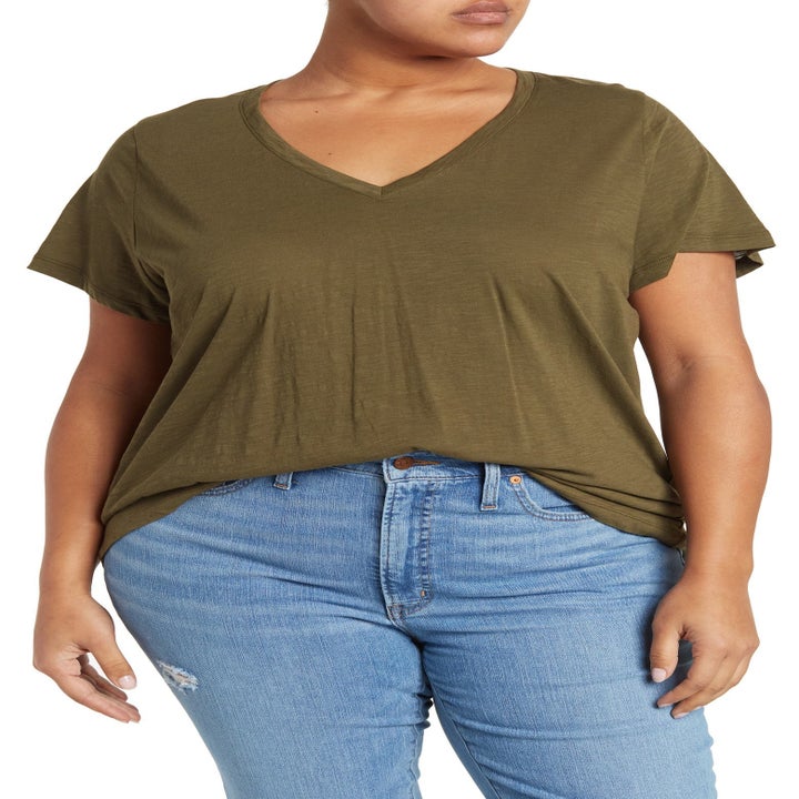 A model in an olive green v-neck tee