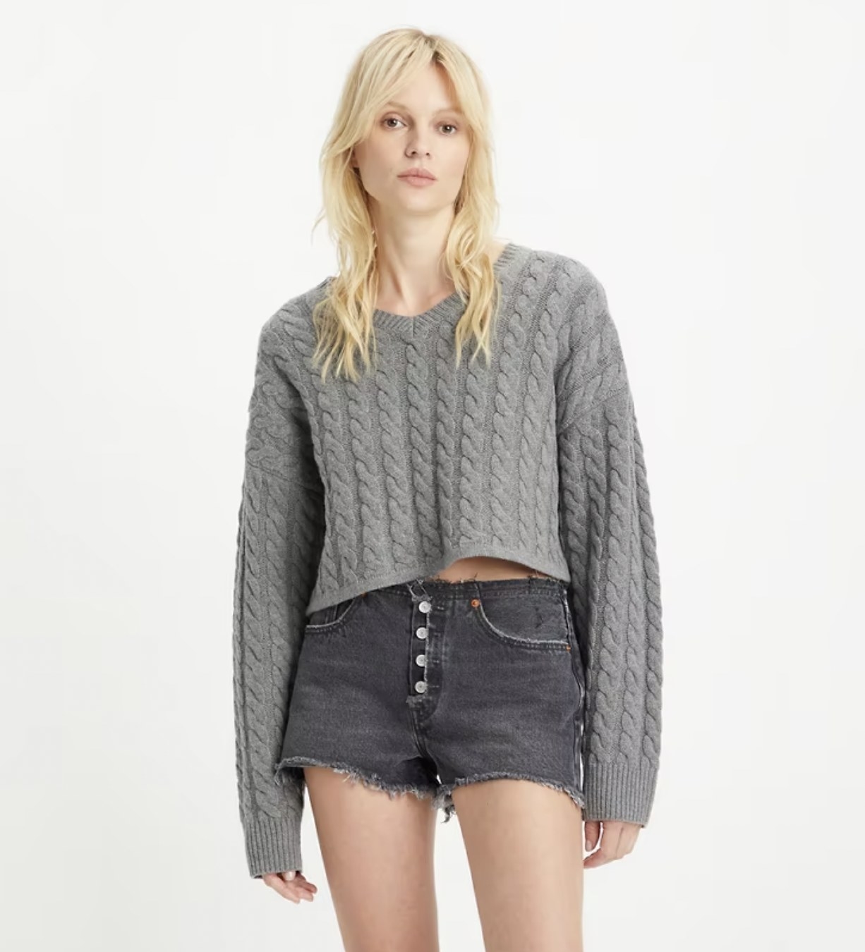 Model wearing the grey v-neck sweater with jean shorts