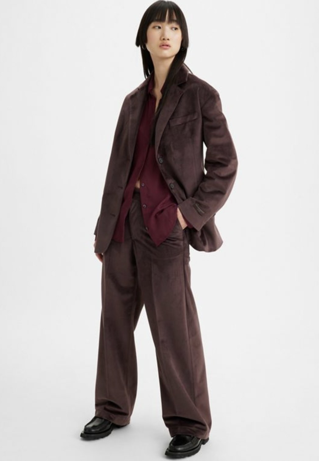 Different model posing with hand in pocket wearing dark brown pants and matching jacket