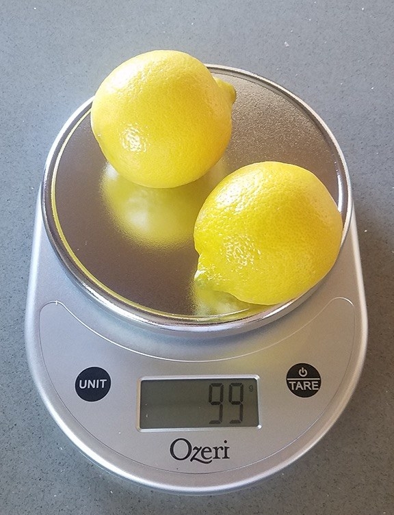 Reviewer&#x27;s photo of the kitchen scale weighing two lemons