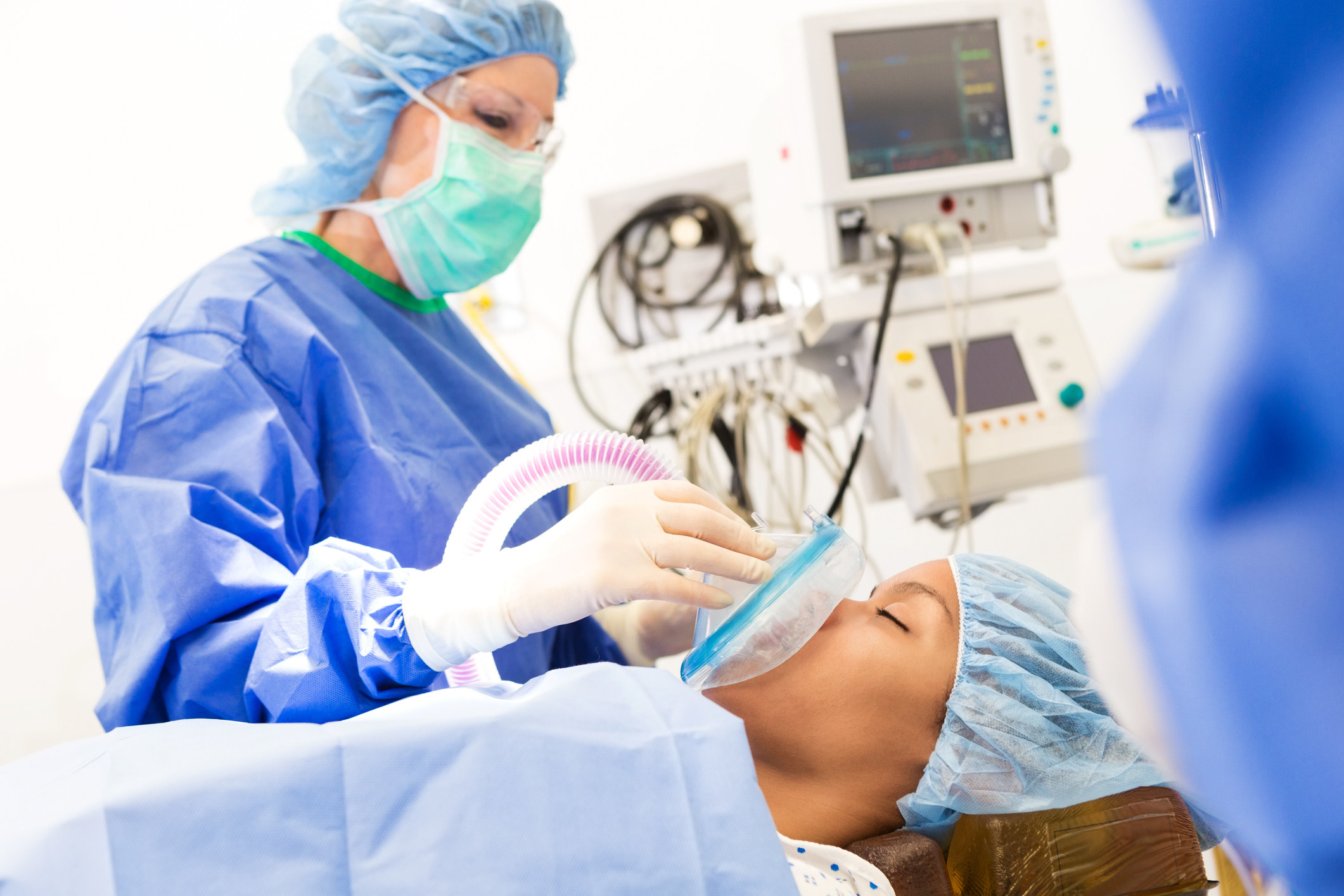 A nurse giving a patient oxygen during surgery