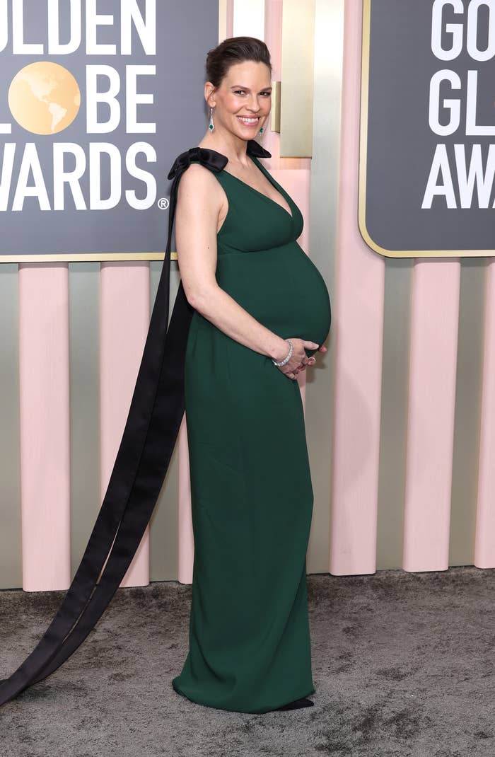 Hilary cradling her baby bump as she posed for photographers at the Golden Globe Awards
