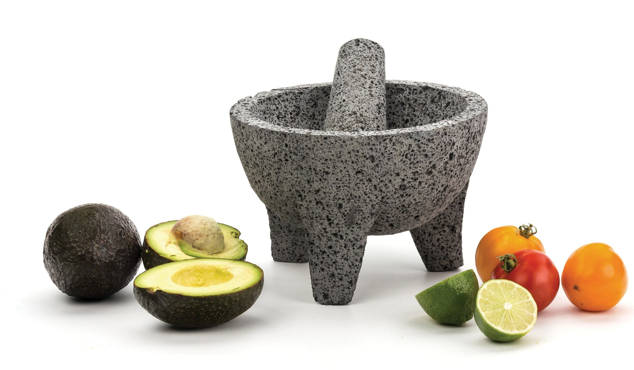 The molcajete surrounded by avocado, tomatoes and limes