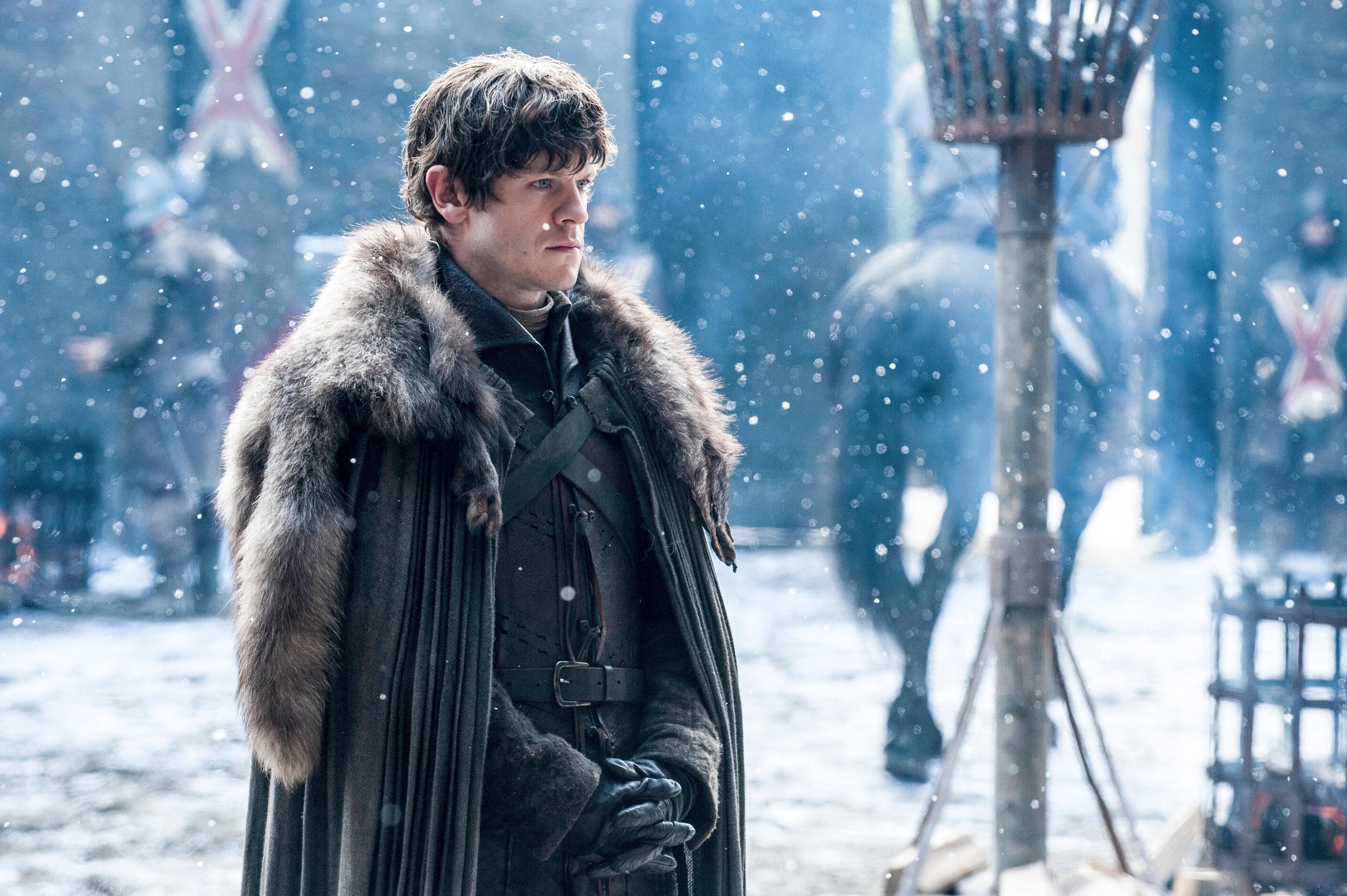 Iwan Rheon as Ramsey in a snowy fortress in a heavy coat