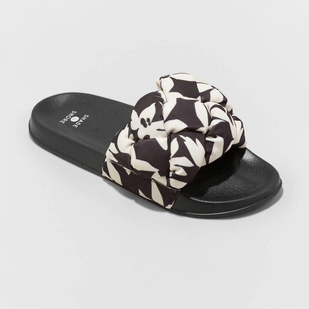 slide sandals with black soles and a black and white knotted strap
