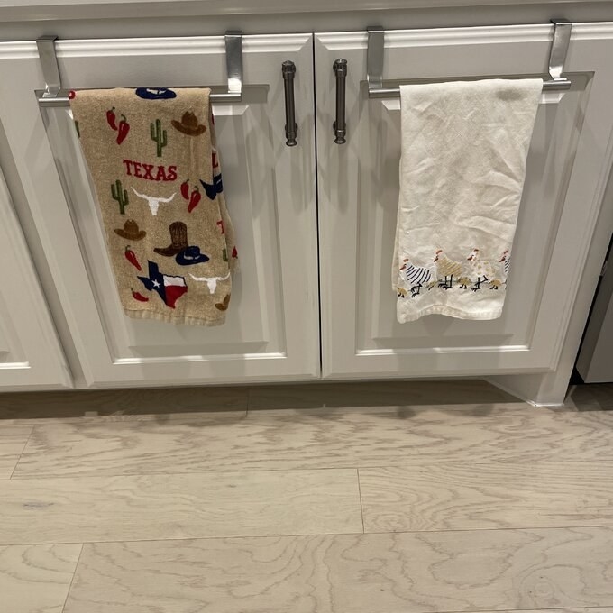The towel bar housing two towels on a cabinet