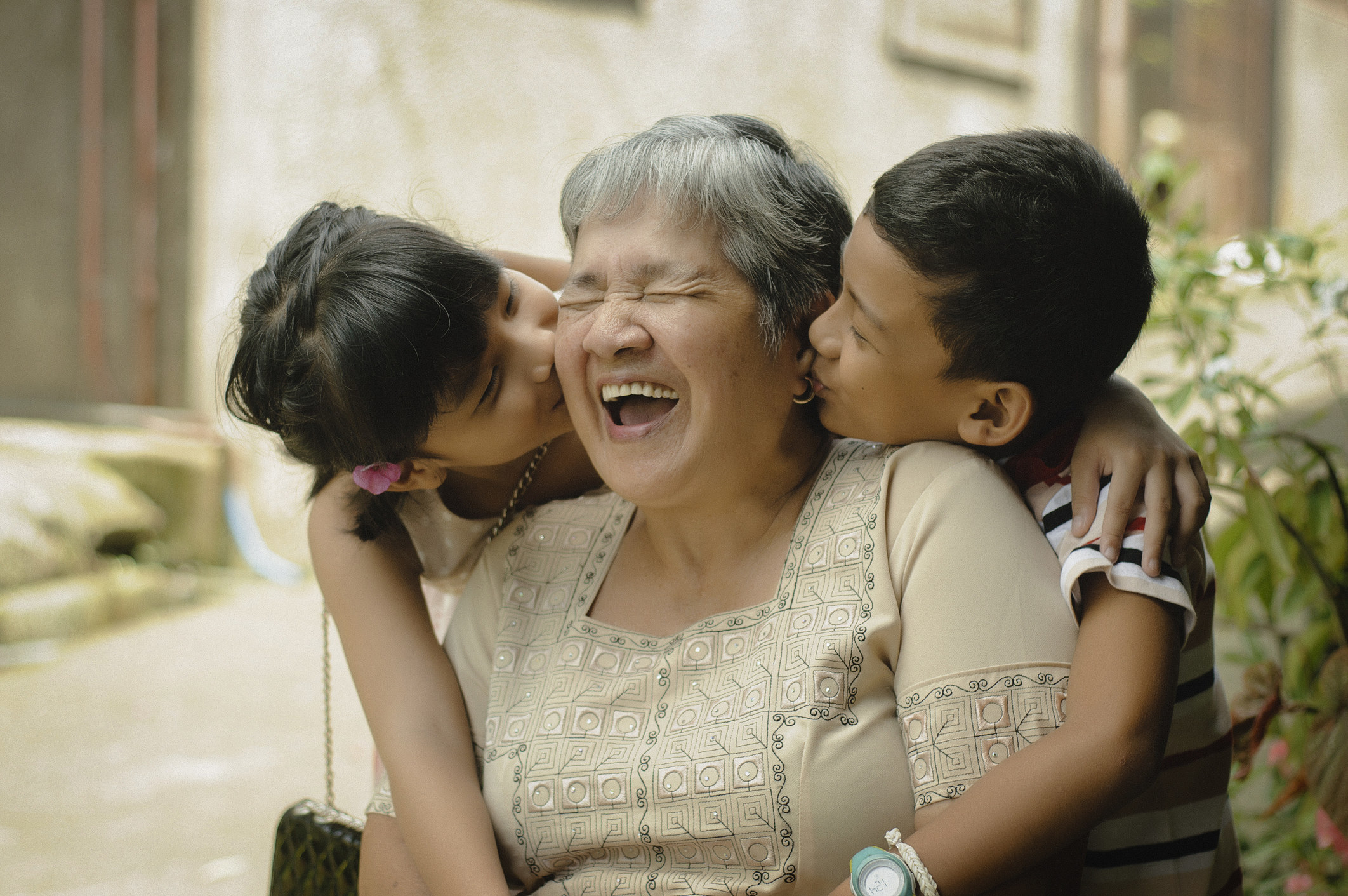 kids kissing their grandmother on each cheek