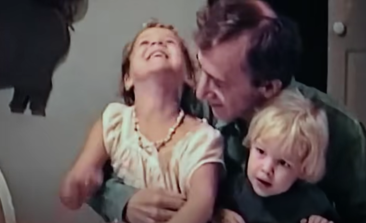 Woody Allen sits with his two children on his lap
