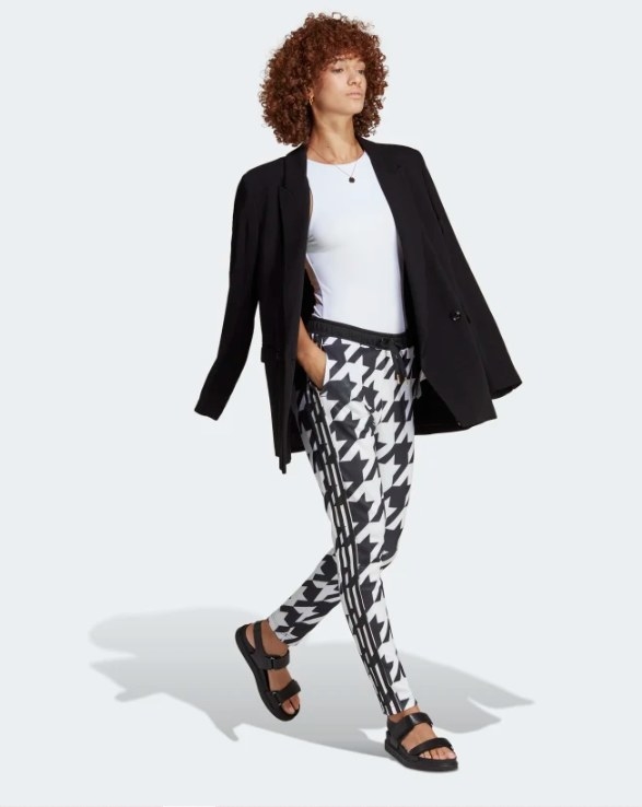 A model wearing the adidas Houndstooth SST track pants