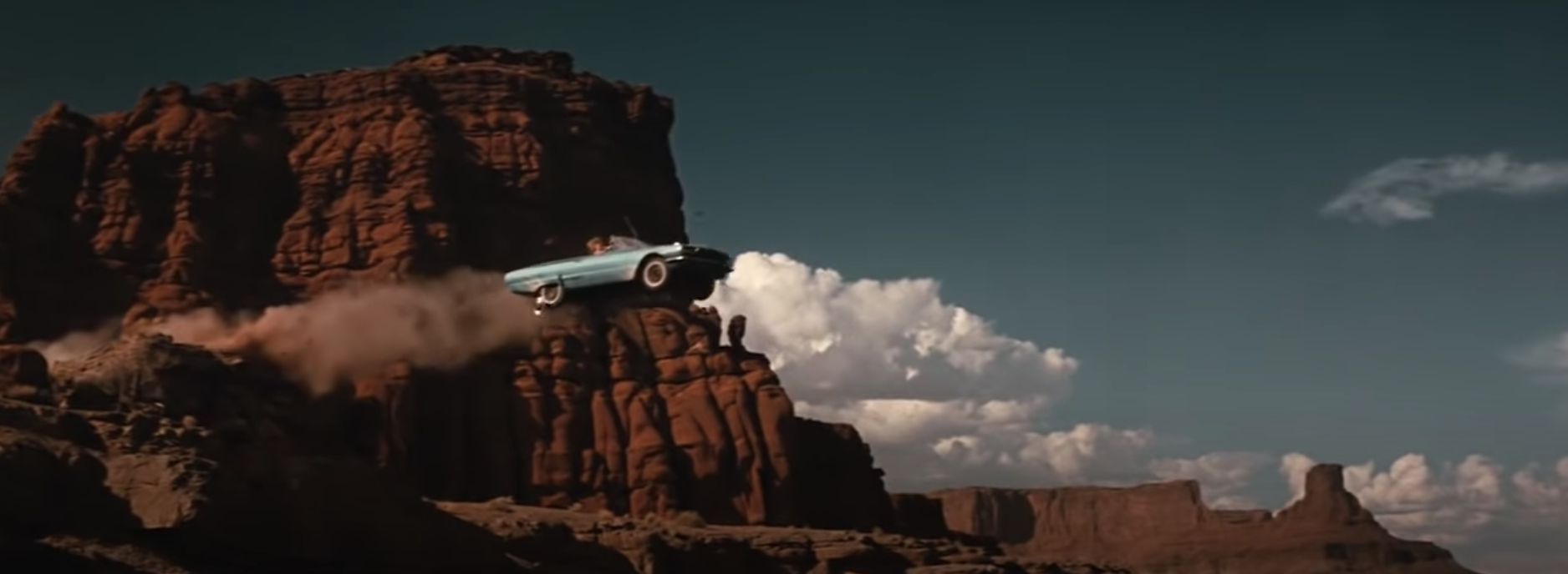 A car flies off the side of a cliff