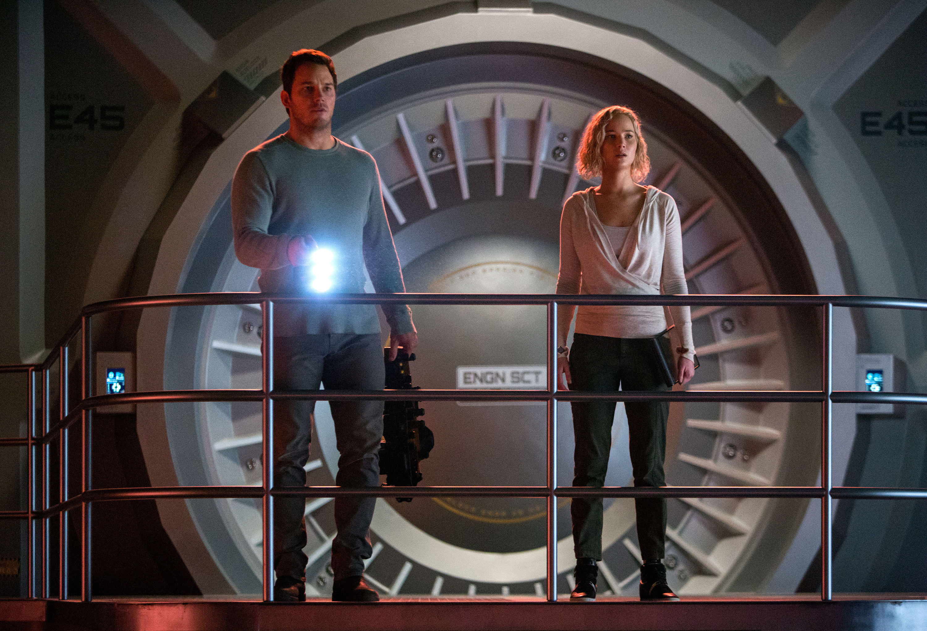 A man and a woman stand on the bridge of a spaceship