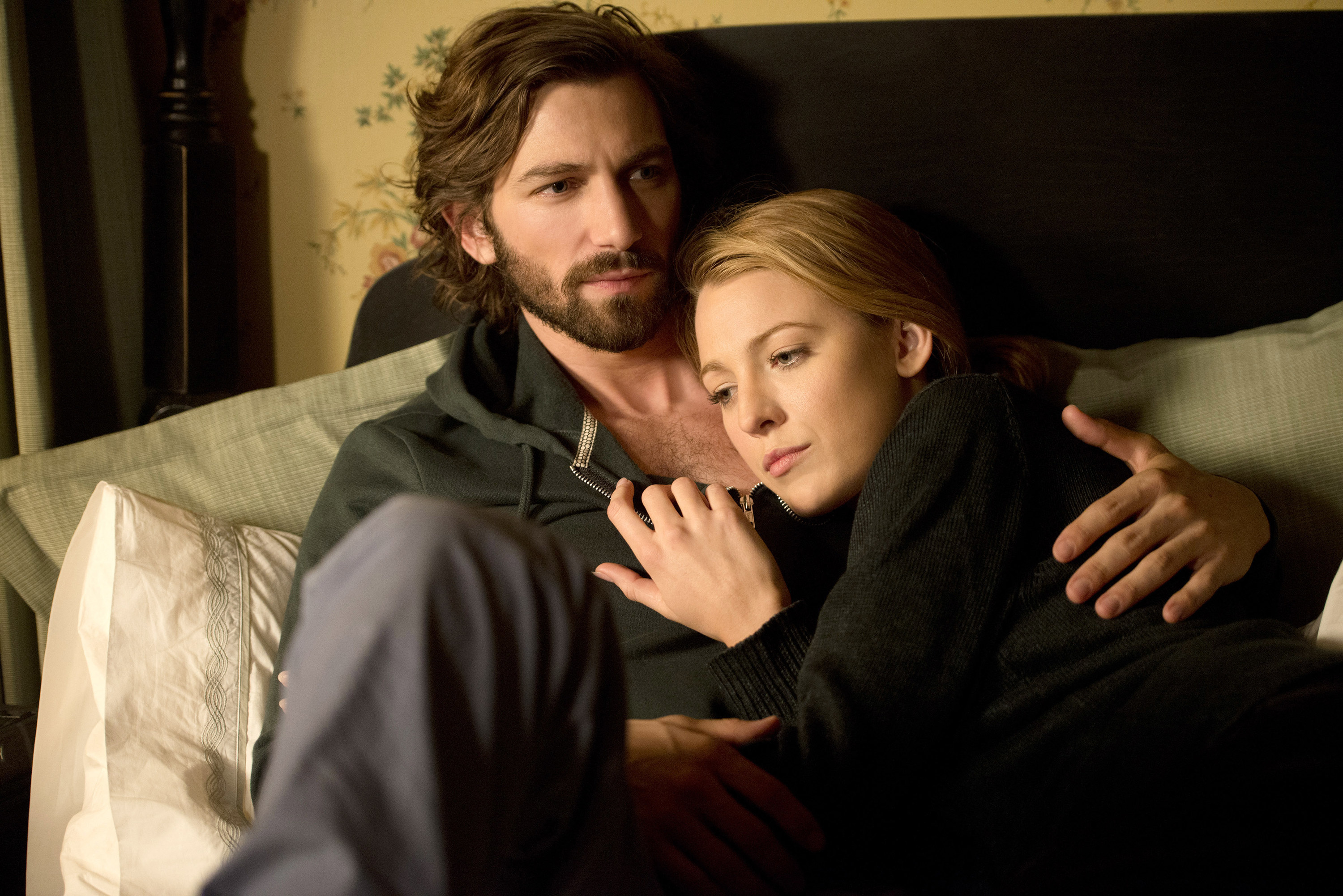 Michiel Huisman and Blake Lively embrace on a couch