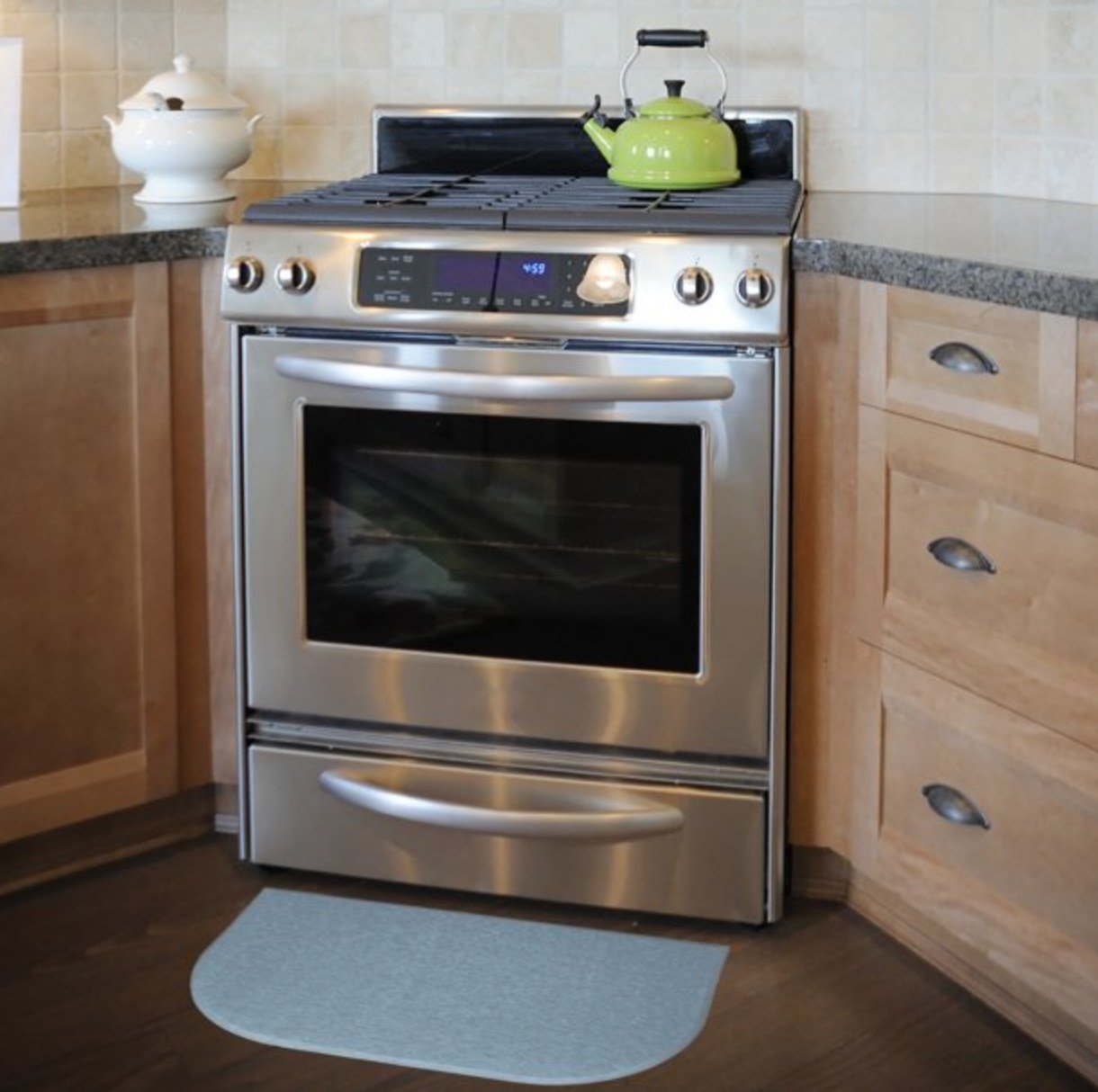 the light blue mat in front of a stove in a decorated kitchen