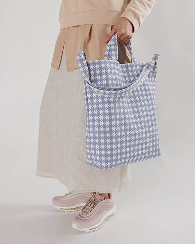 model with the purple and white checkered bag