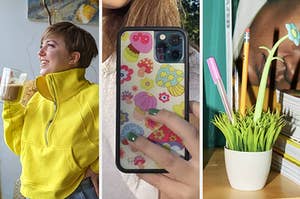 a person wearing a bright sweater, a person holding up a phone case, and a bunch of pens in a fake pot of grass
