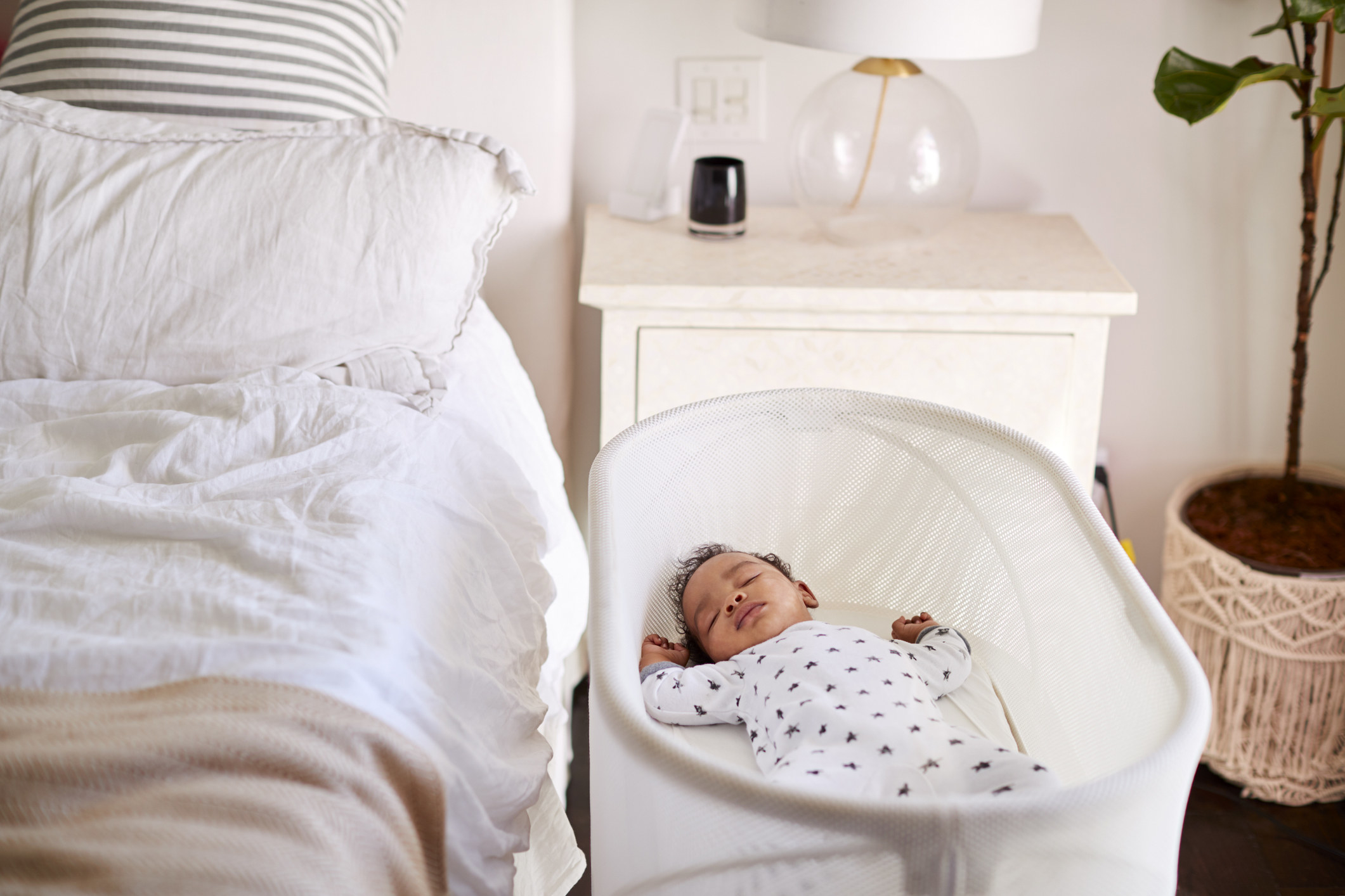 A baby sleeping in a bassinet.
